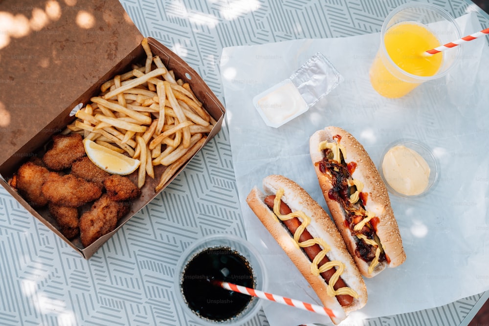 a couple of hot dogs sitting next to a box of fries