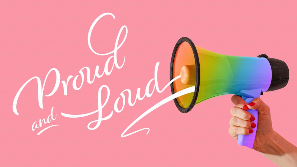 a hand holding a rainbow colored megaphone with the words proud and loud