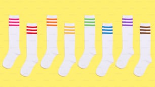 five pairs of white socks with multi - colored stripes