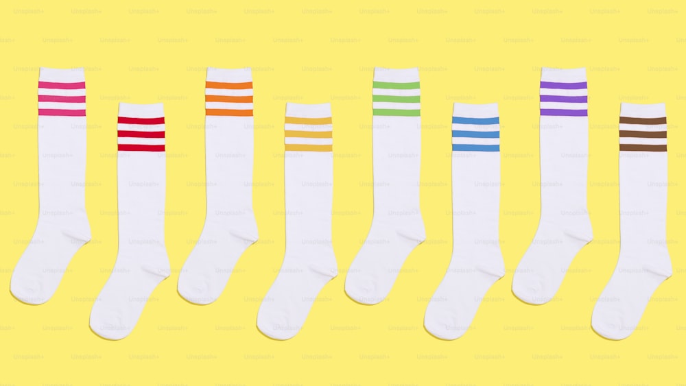 five pairs of white socks with multi - colored stripes