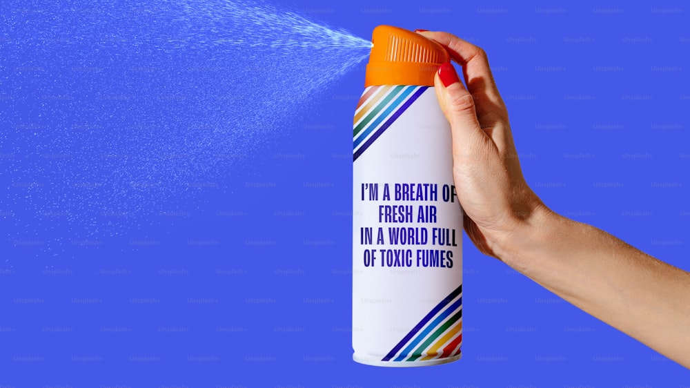 uma pessoa pulverizando um spray de água em um fundo azul