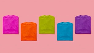 um grupo de cinco t-shirts em um fundo rosa