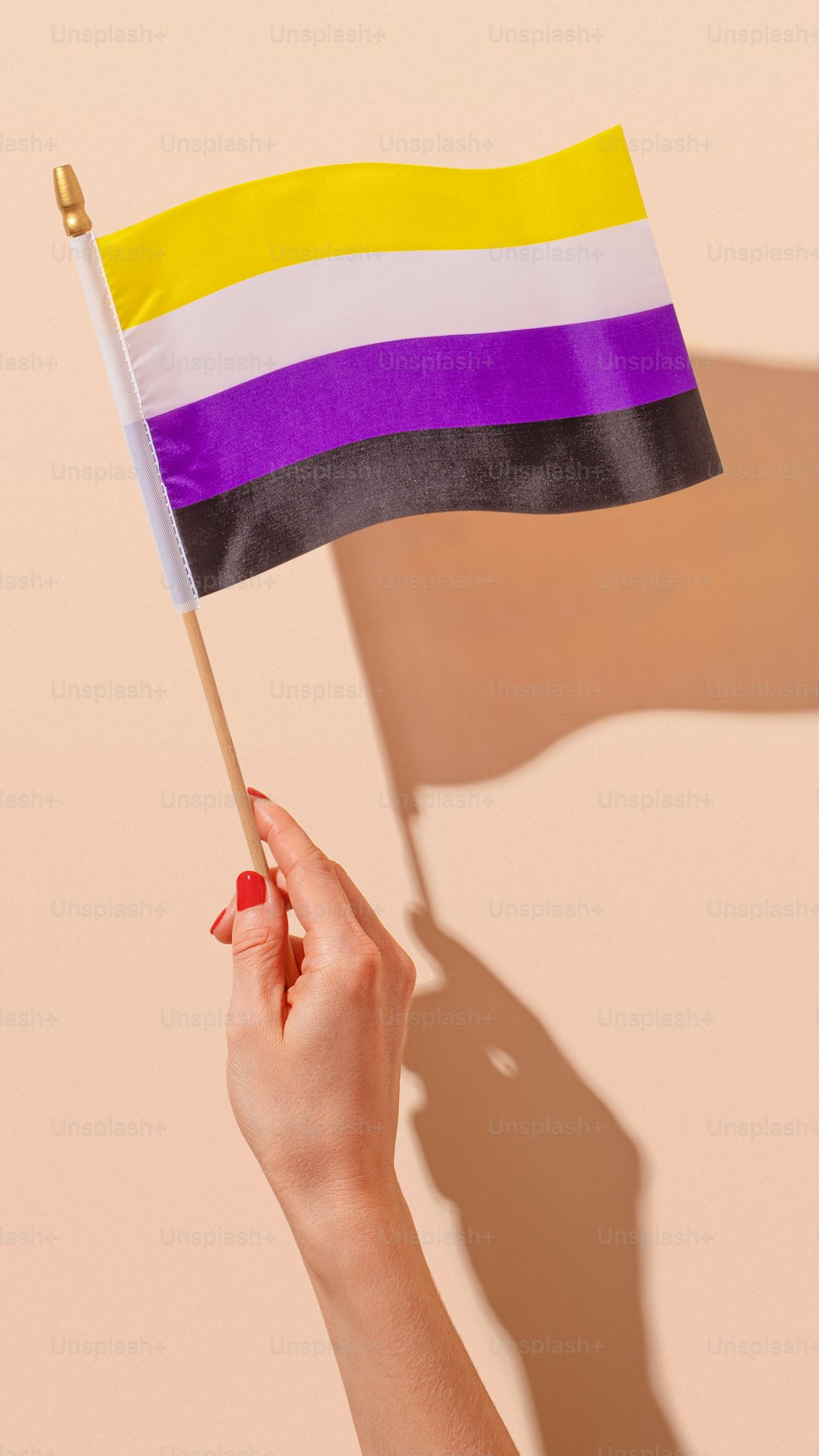 uma mulher segurando uma bandeira do arco-íris em sua mão