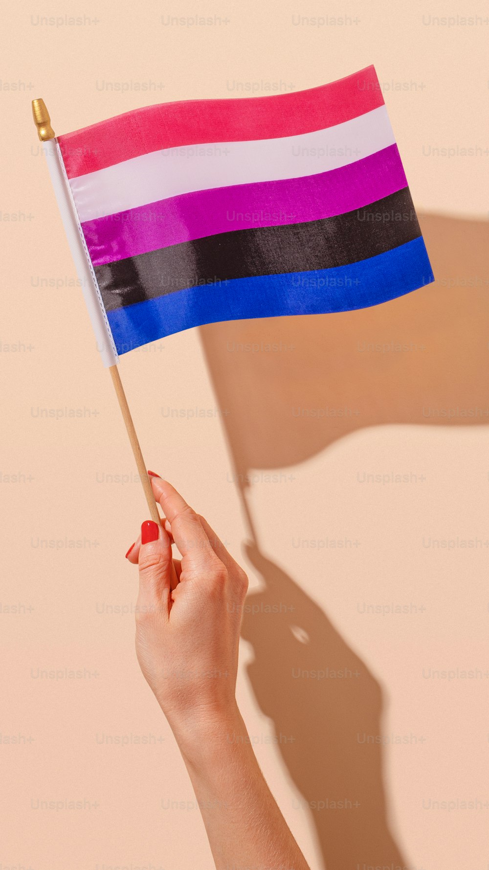 uma mulher segurando uma bandeira do arco-íris em sua mão