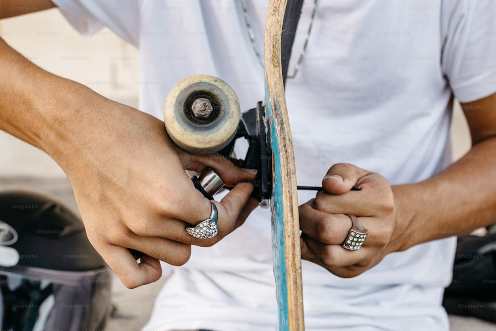 a man holding a skateboard with a grinder in his hands