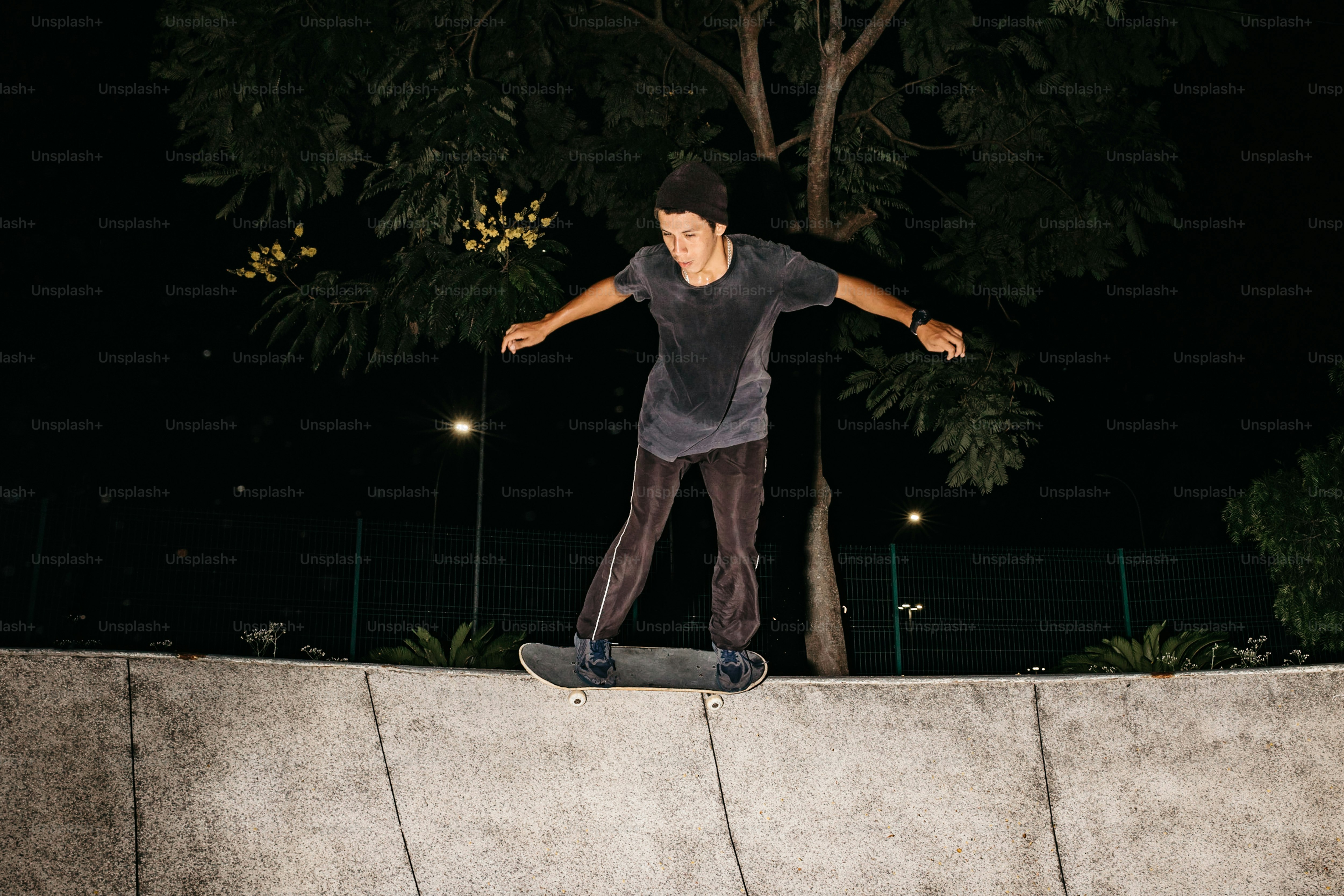 Un hombre montando una patineta encima de una pared de cemento