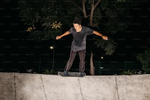 a man riding a skateboard on top of a cement wall