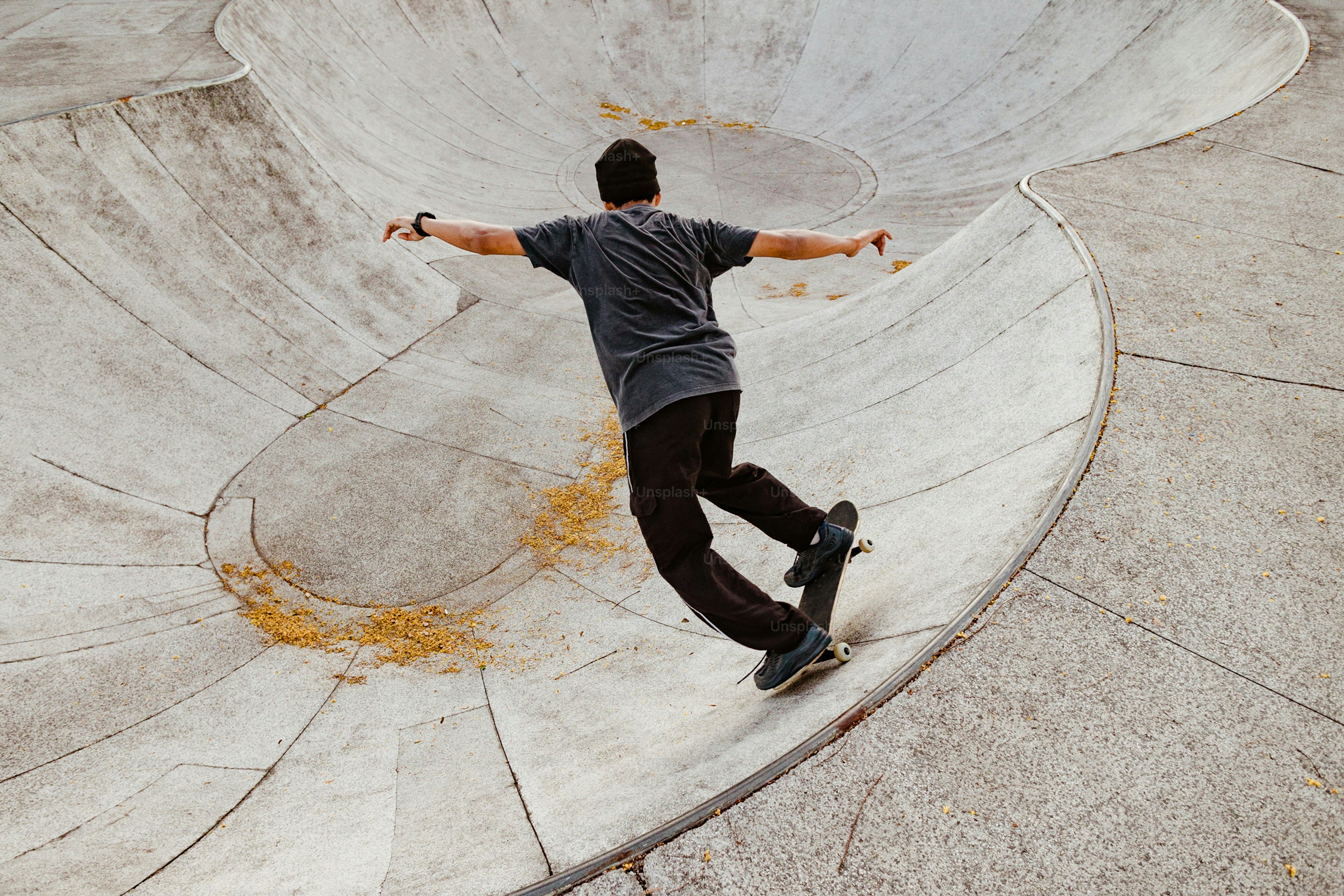 Un hombre montando una patineta al costado de una rampa