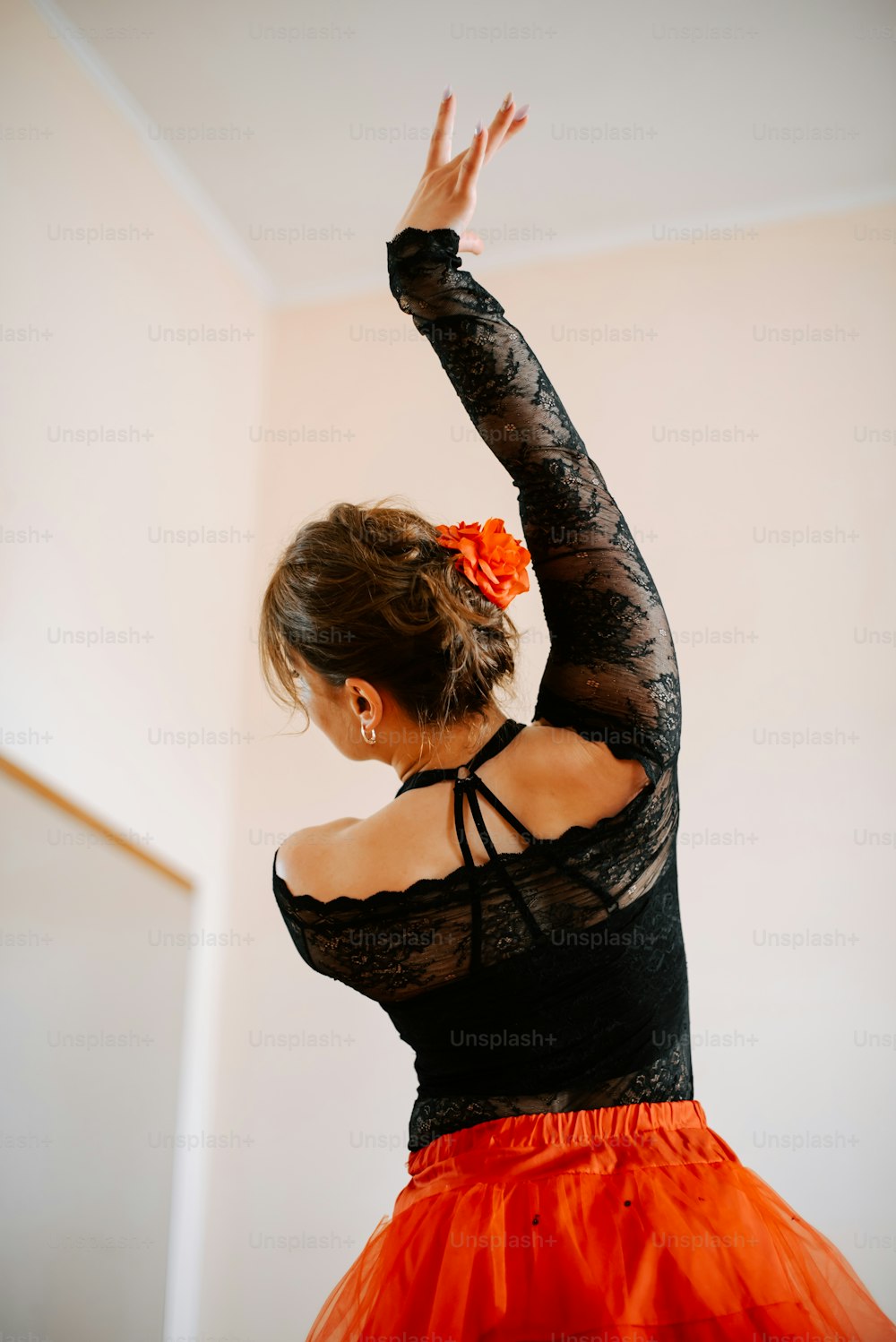 a woman in a black top and orange skirt