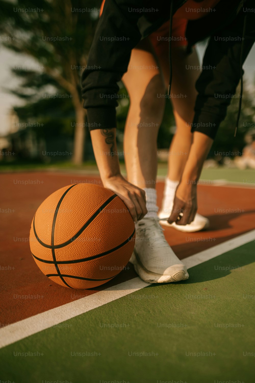 une personne attachant un ballon de basket sur un terrain
