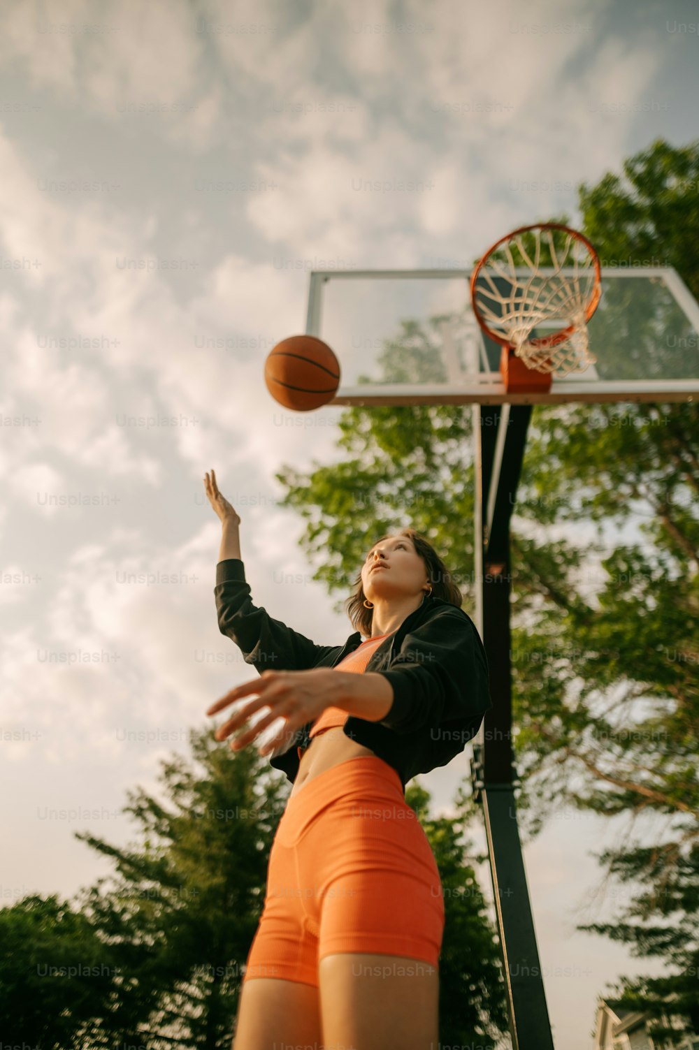 a woman in an orange shorts is playing basketball