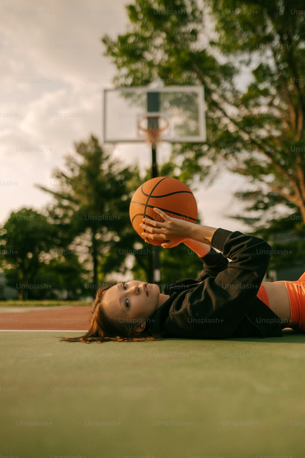 a woman laying on the ground with a basketball