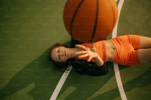 a woman laying on the floor with a basketball