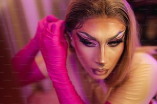 a woman with makeup and pink gloves on