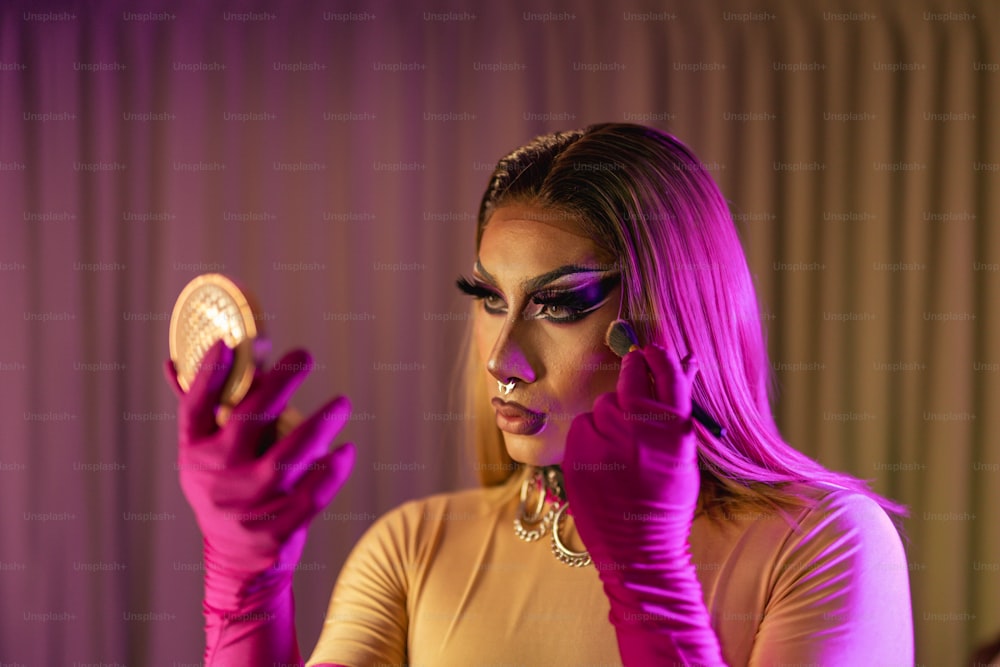 a woman with purple makeup holding a mirror