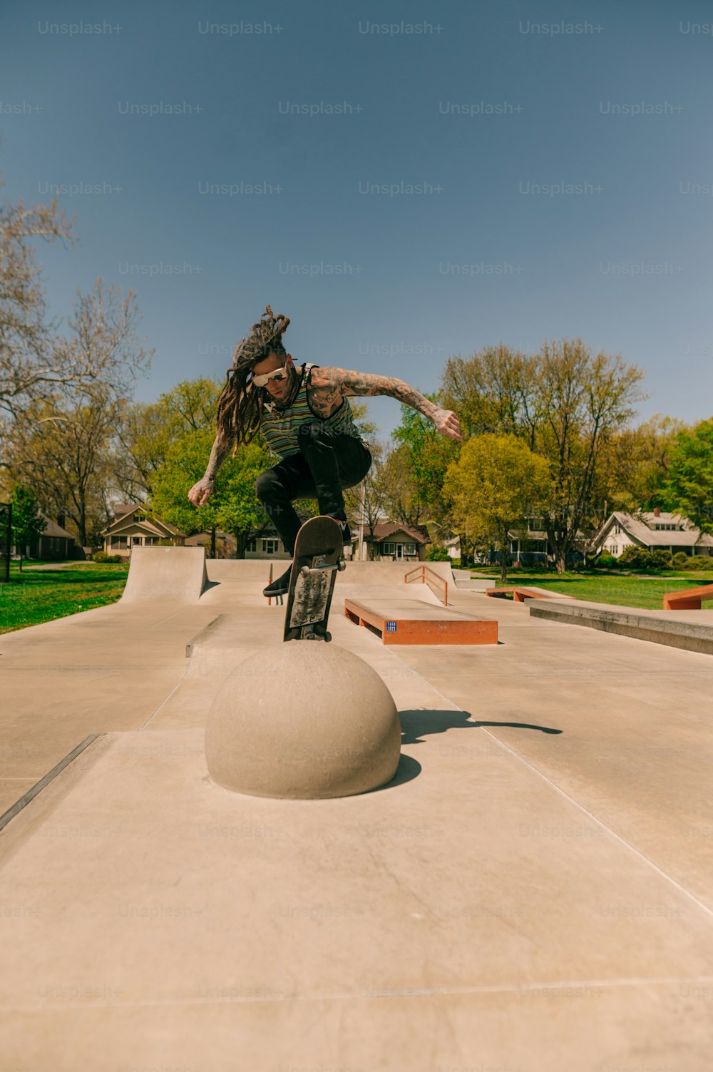 Un uomo che cavalca uno skateboard in cima a una palla di cemento