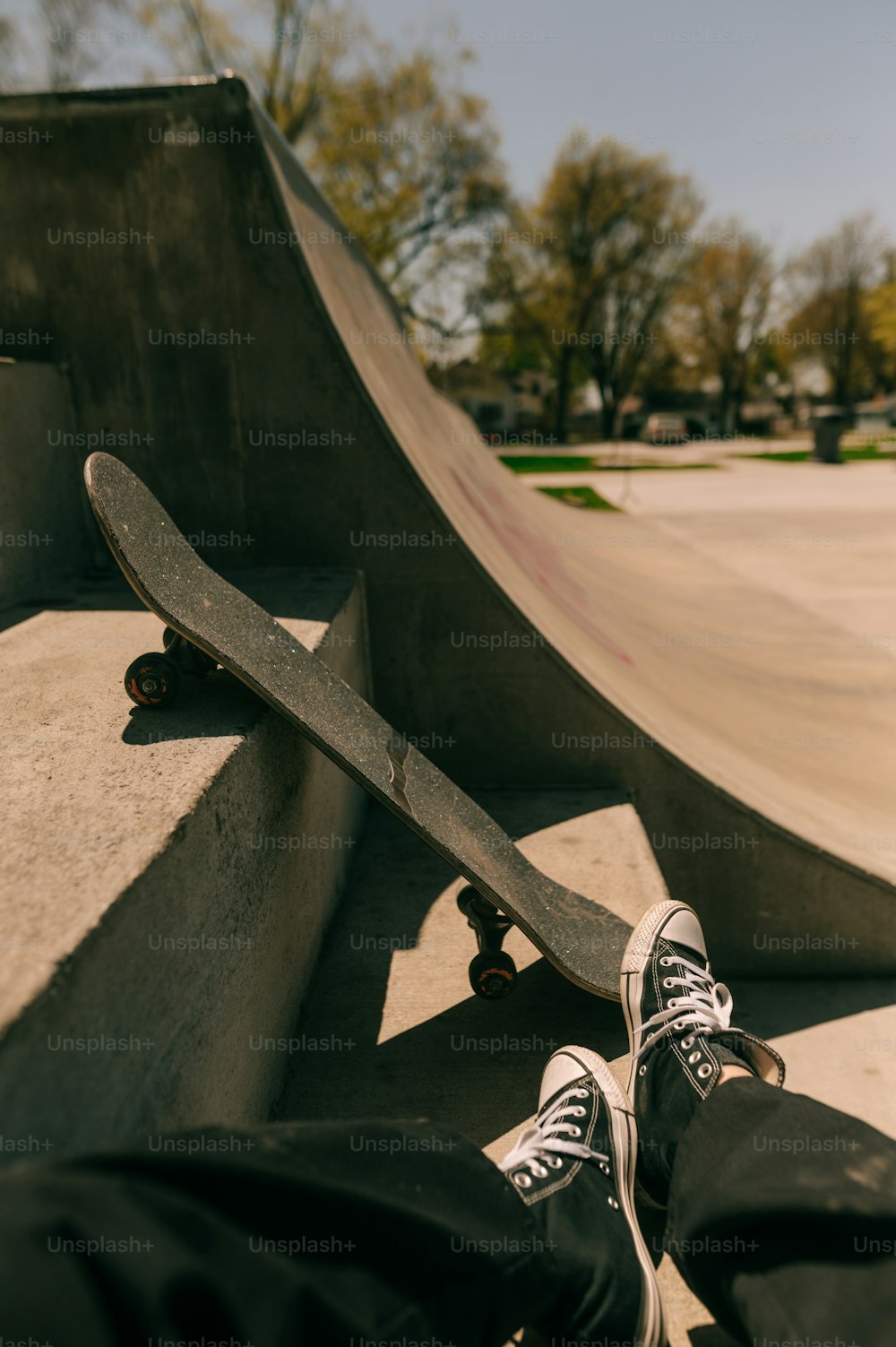 une personne avec les pieds sur une planche à roulettes dans un skatepark