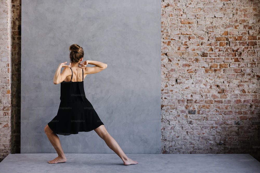 A woman in a black dress is doing a yoga pose photo – Human body Image on  Unsplash