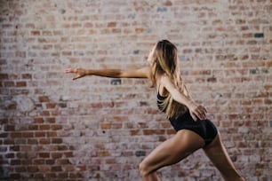Una mujer con un top negro está haciendo una pose de yoga