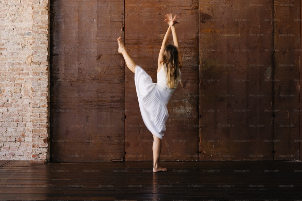 a woman in a white dress is dancing