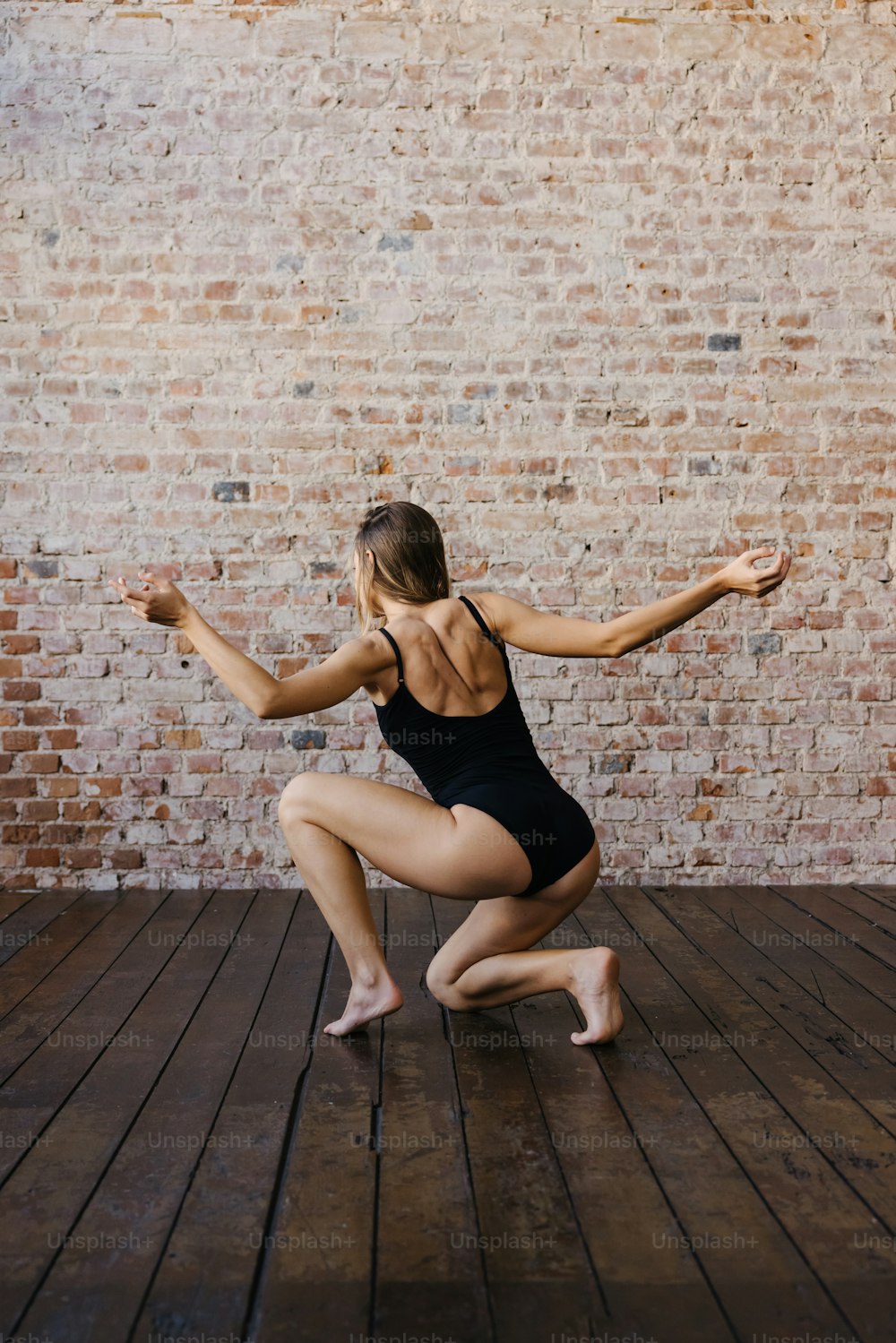 Una donna in un body nero che fa una posa di danza