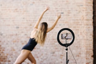 a woman standing in front of a camera on a tripod