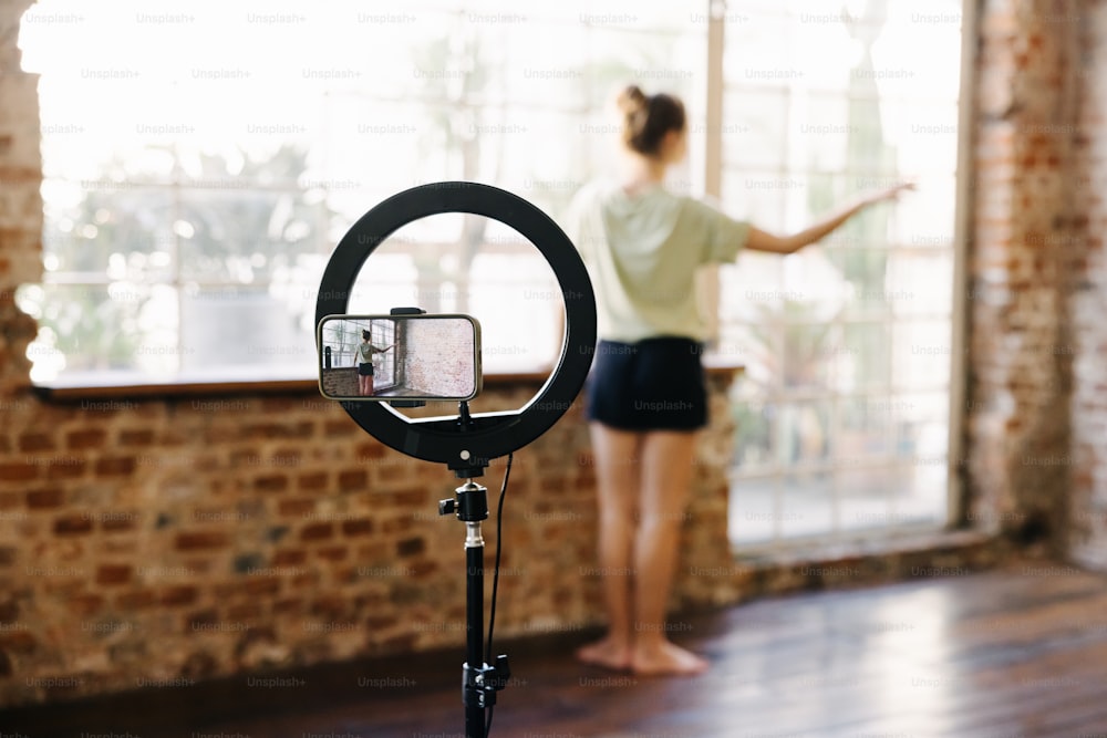 a woman standing in a room with a camera on a tripod