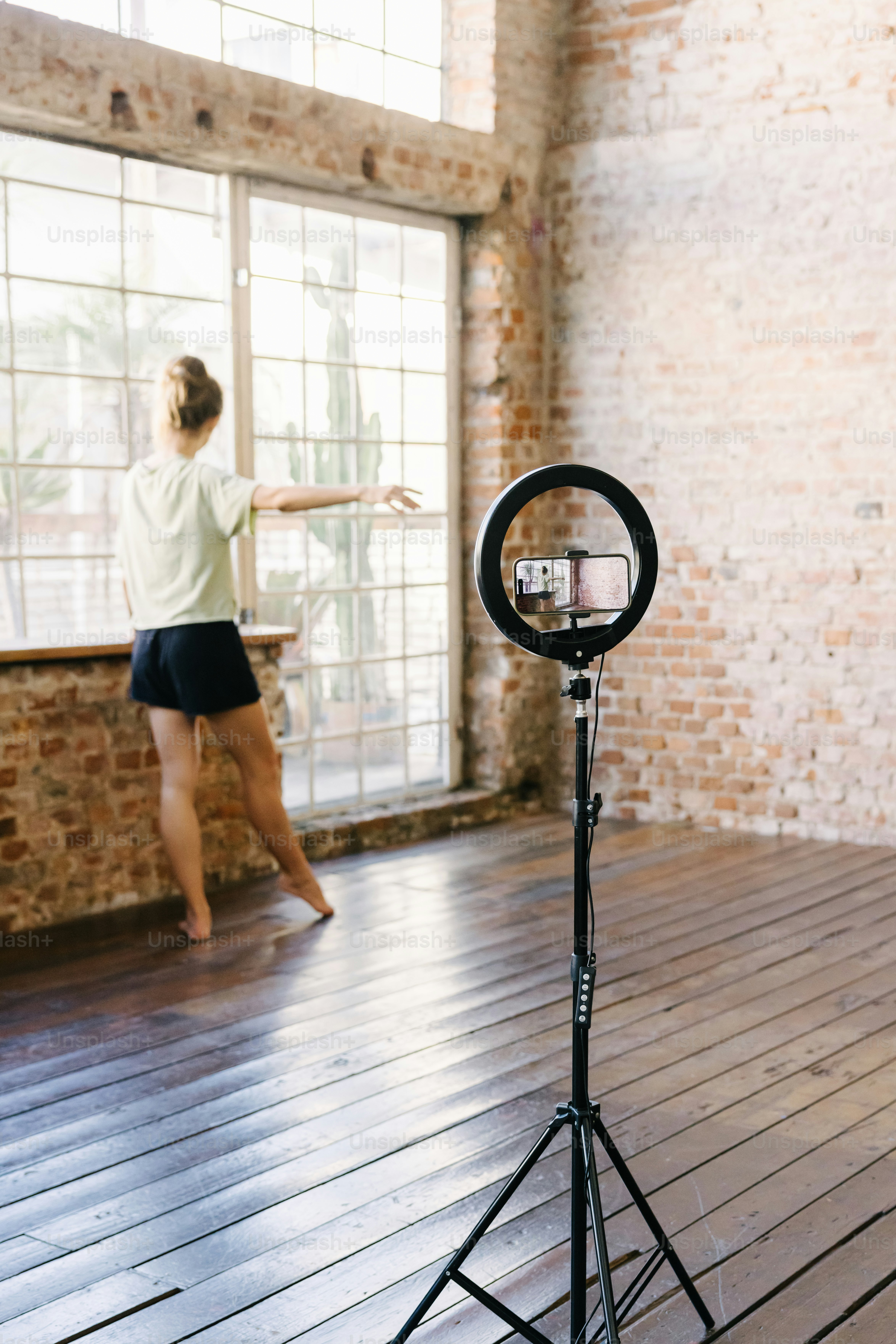 a woman standing in a room with a camera on a tripod