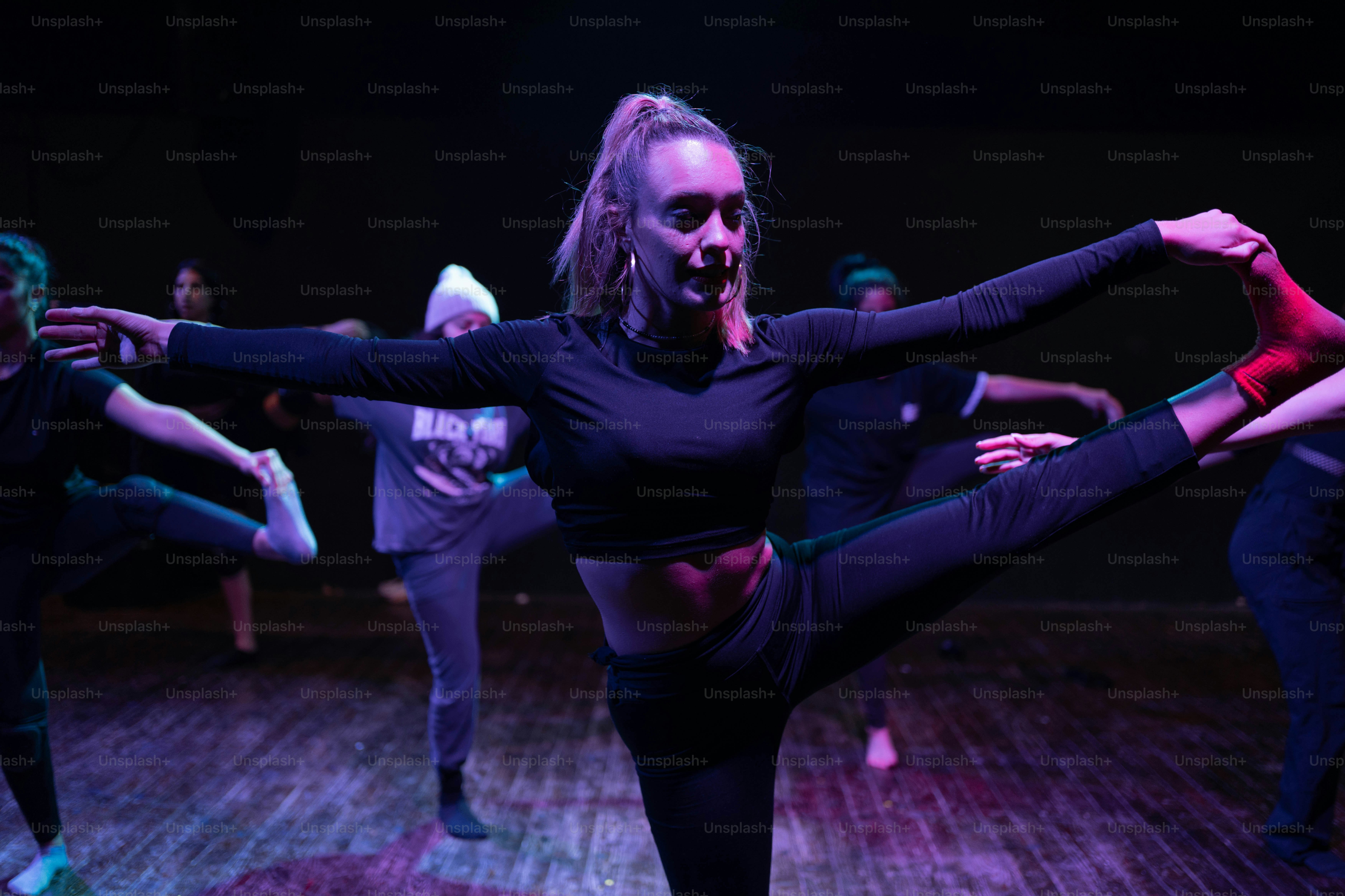 A group of people dancing in a dark room photo – Dance studio Image on ...
