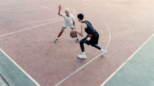 two men playing basketball on a basketball court