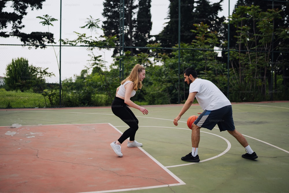 Un hombre y una mujer jugando un partido de baloncesto