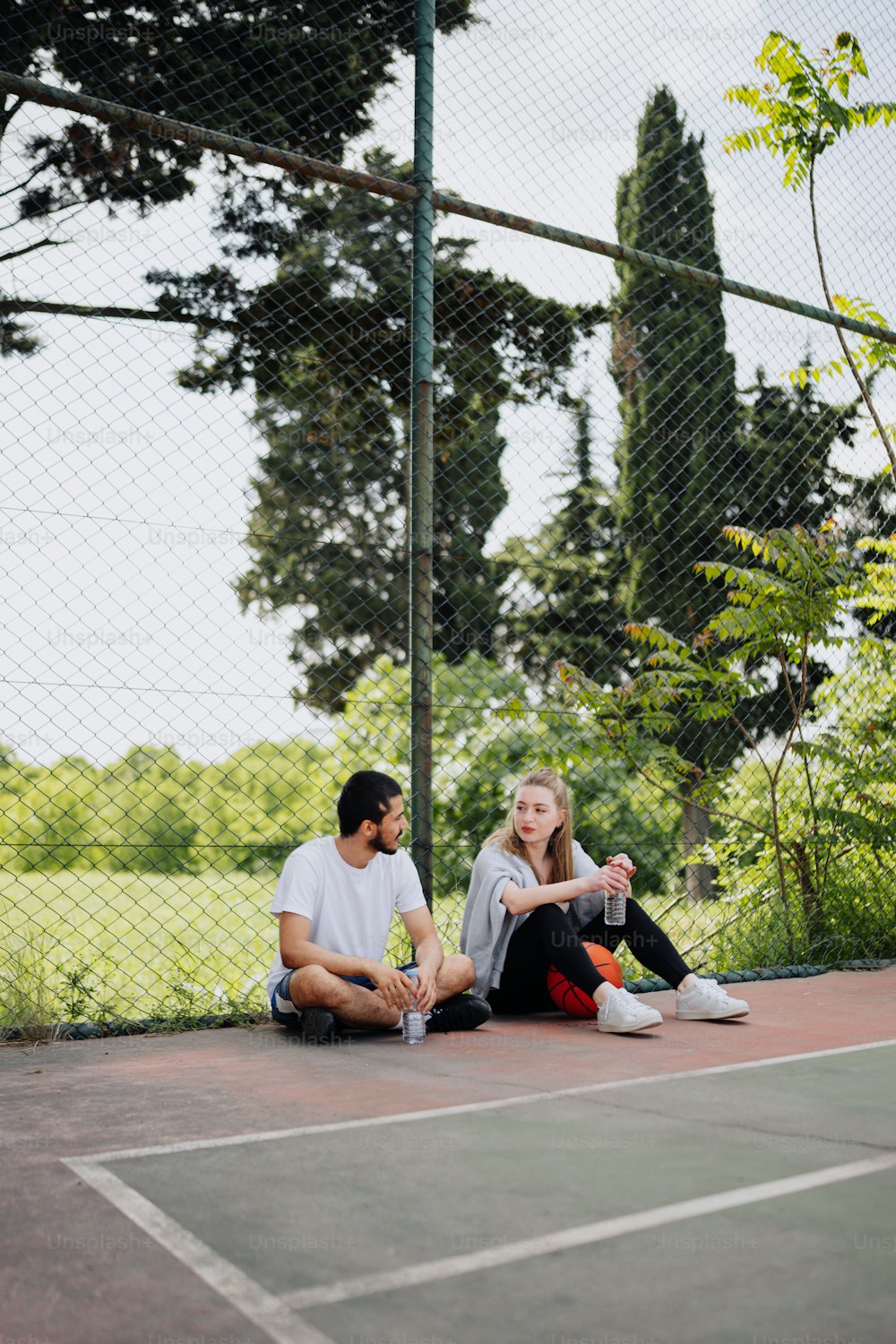 a man and a woman sitting on a tennis court