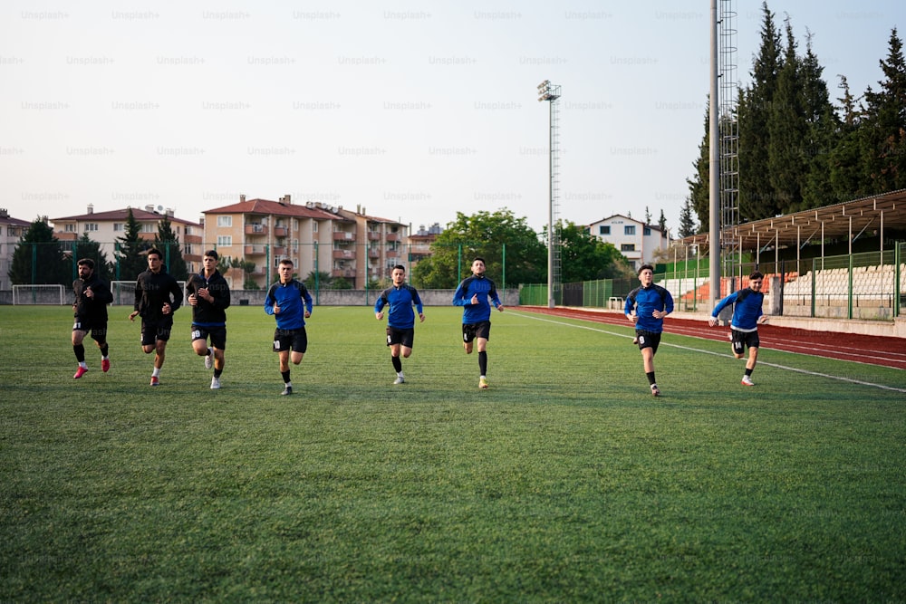 um grupo de jovens correndo por um campo de futebol