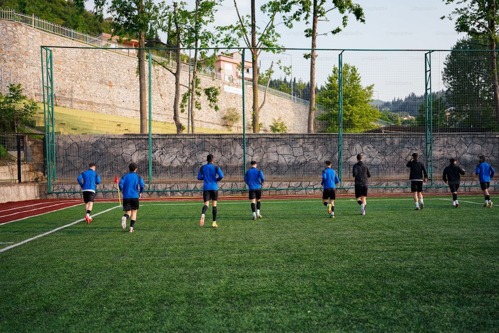 a group of men standing on top of a soccer field