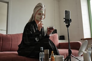 Una mujer sentada en un sofá sosteniendo una copa de vino