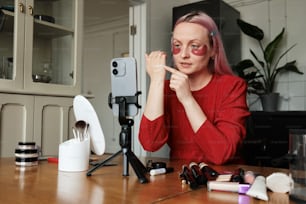 a woman sitting at a table with a cell phone in front of her