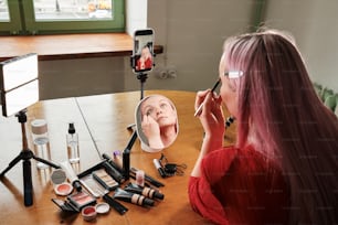 Una mujer está tomando una foto de su maquillaje