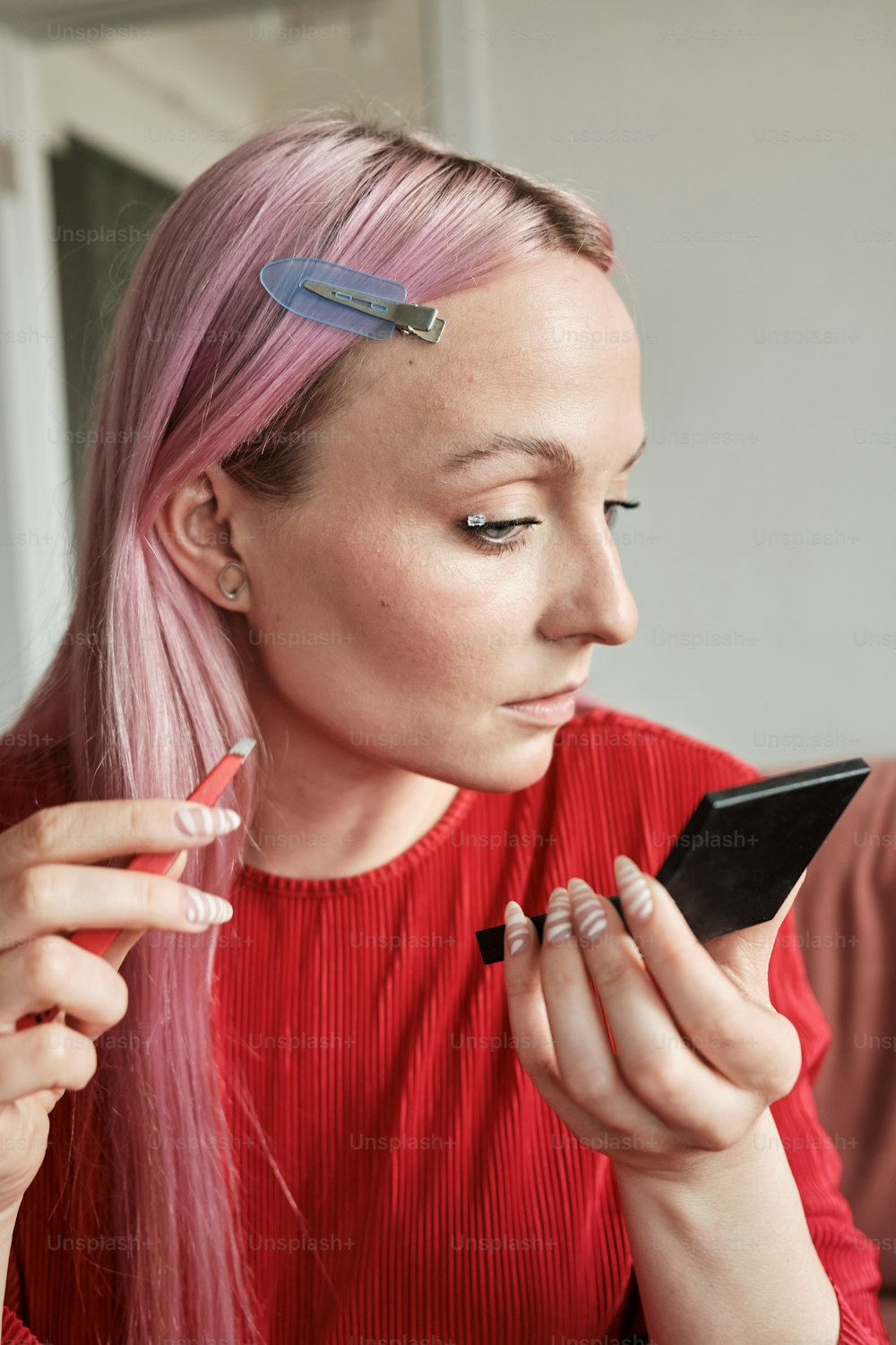 uma mulher com cabelo rosa usando um telefone celular