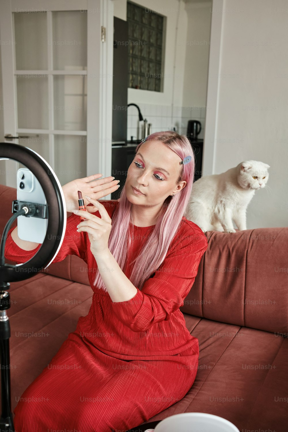 a woman with pink hair sitting on a couch