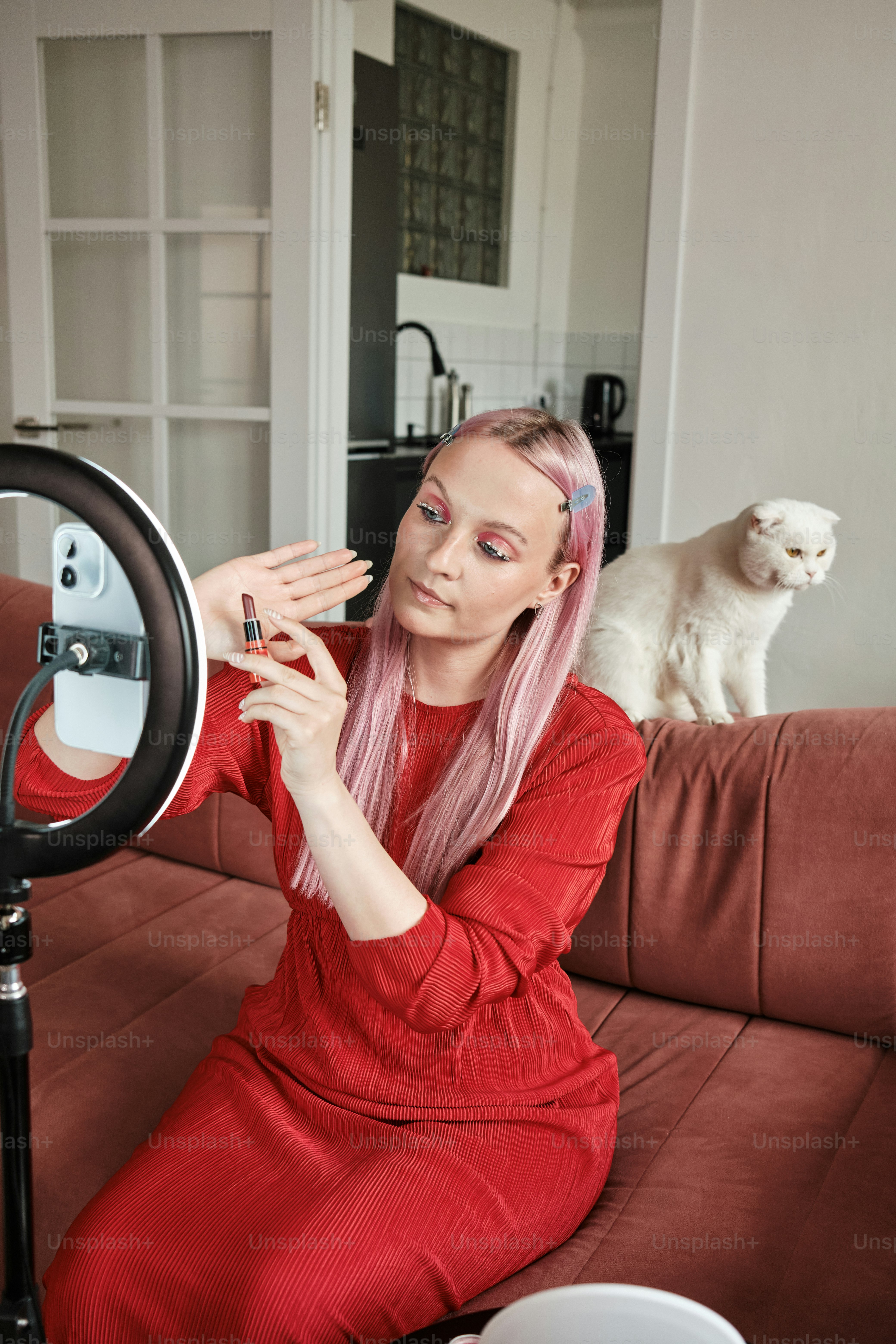 the makeup artist demonstrates the lipstick in front of the phone camera