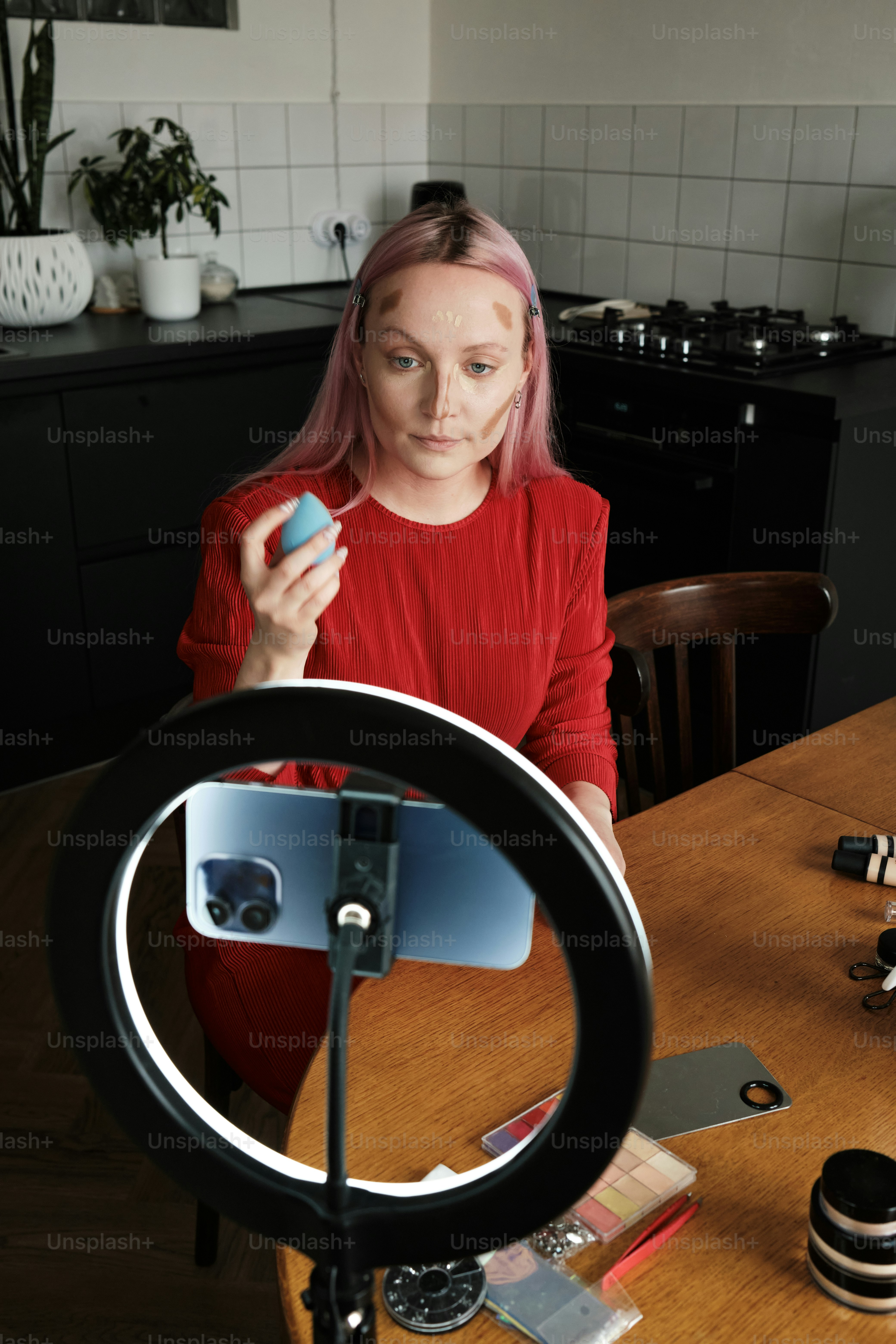a woman sitting at a table in front of a camera
