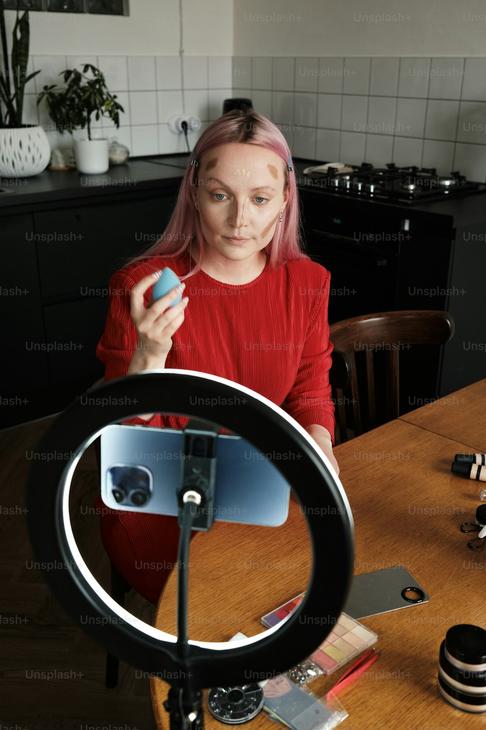 uma mulher sentada em uma mesa em frente a uma câmera