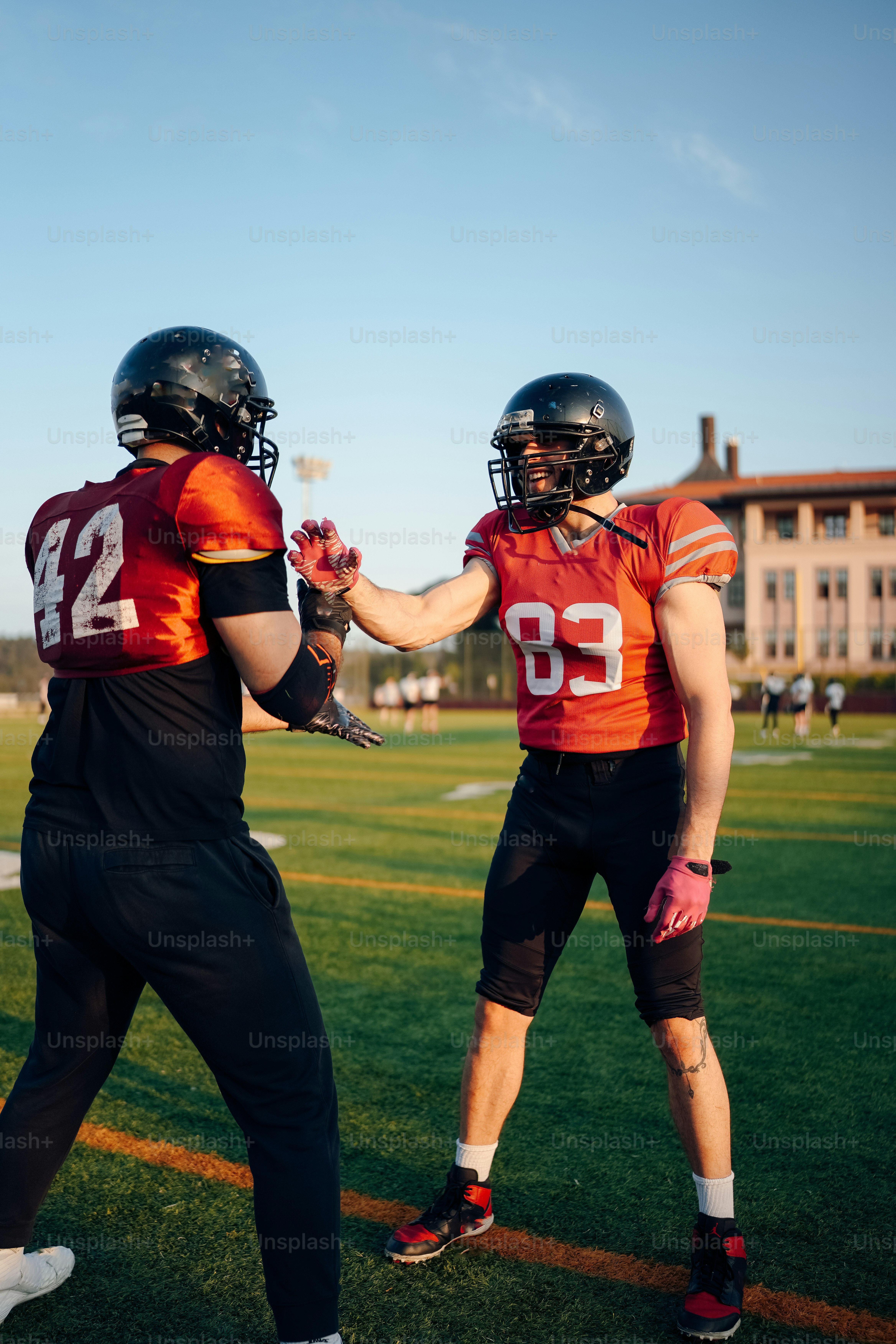a couple of football players standing on top of a field