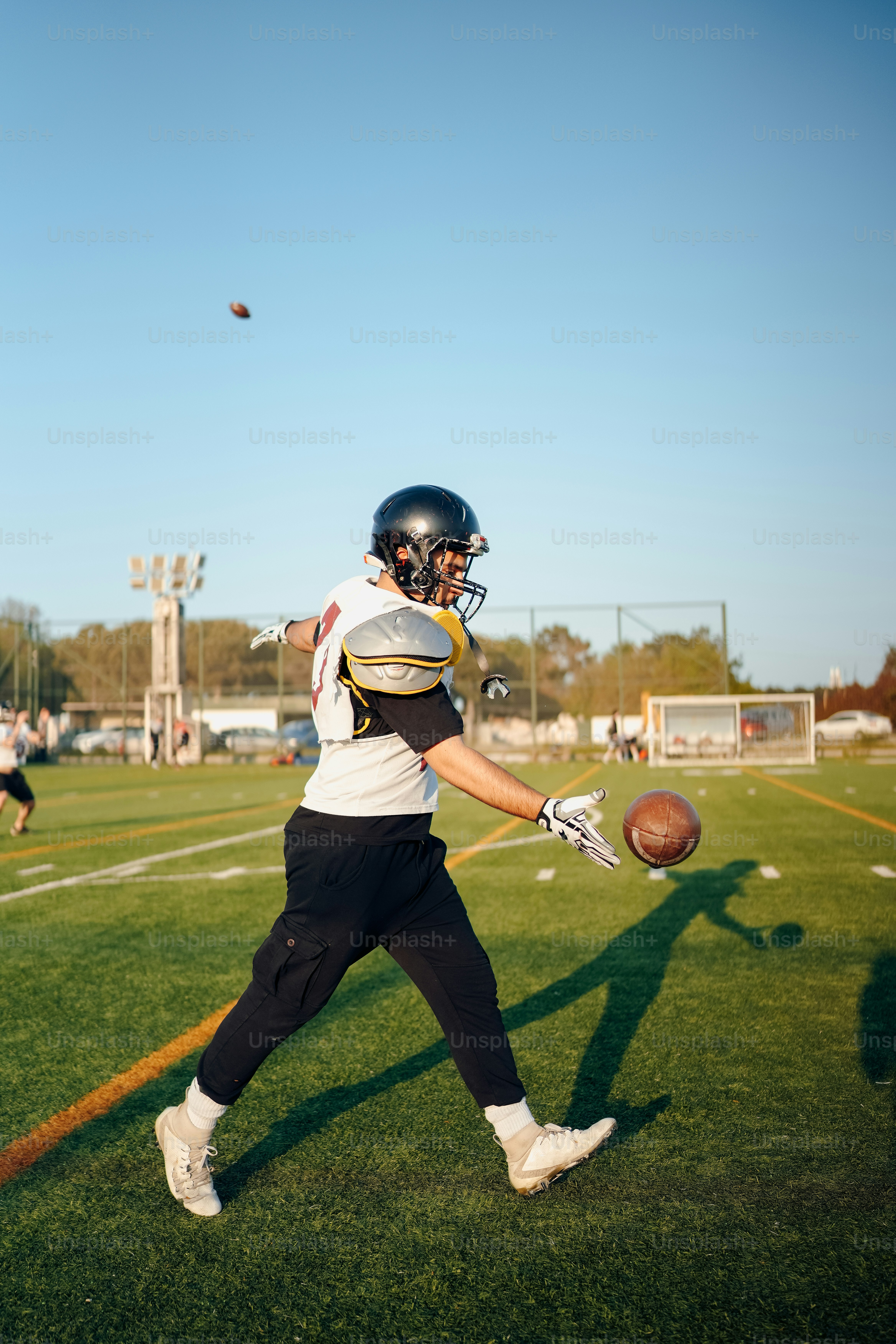 a football player holding a football on a field