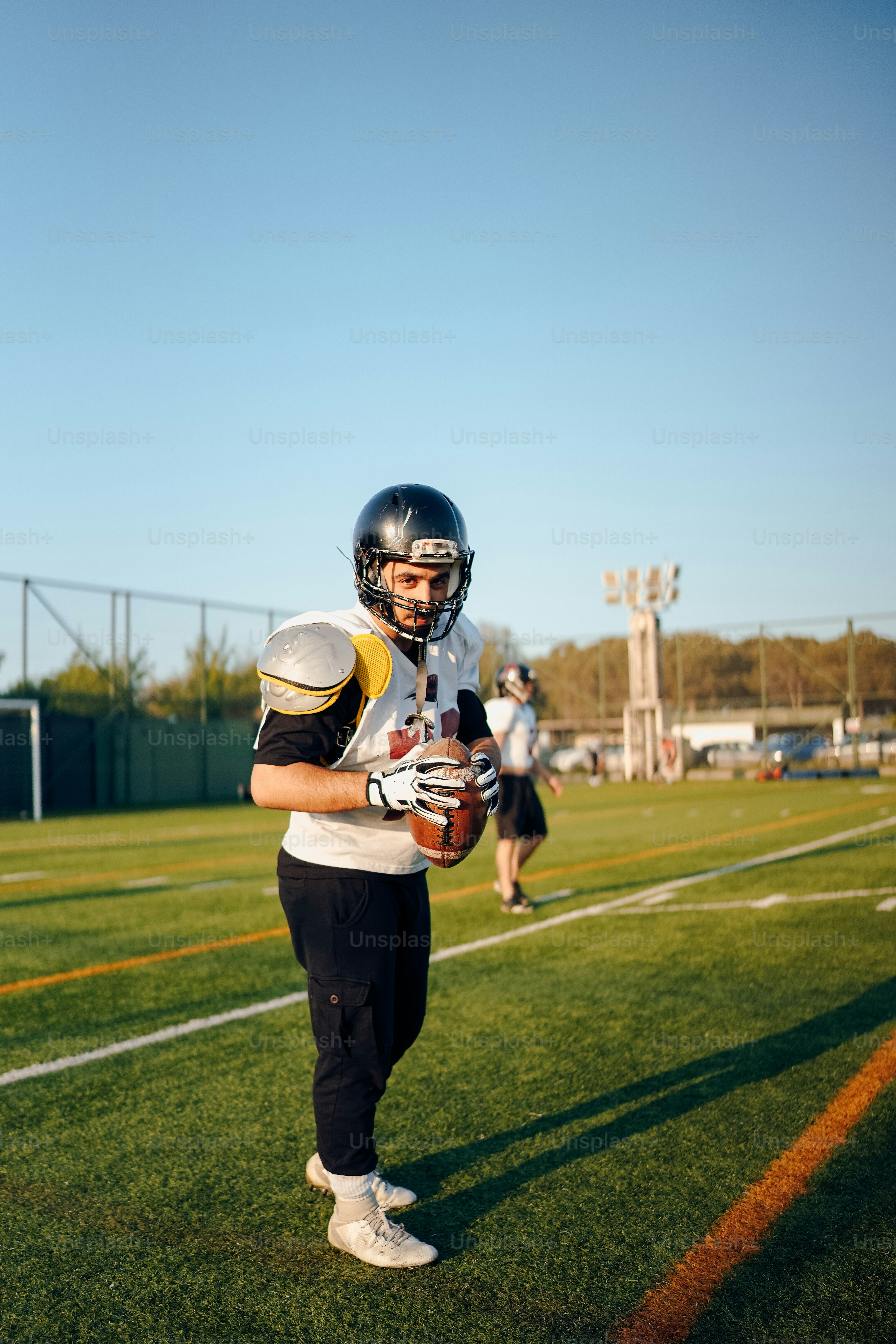 a football player holding a football on a field