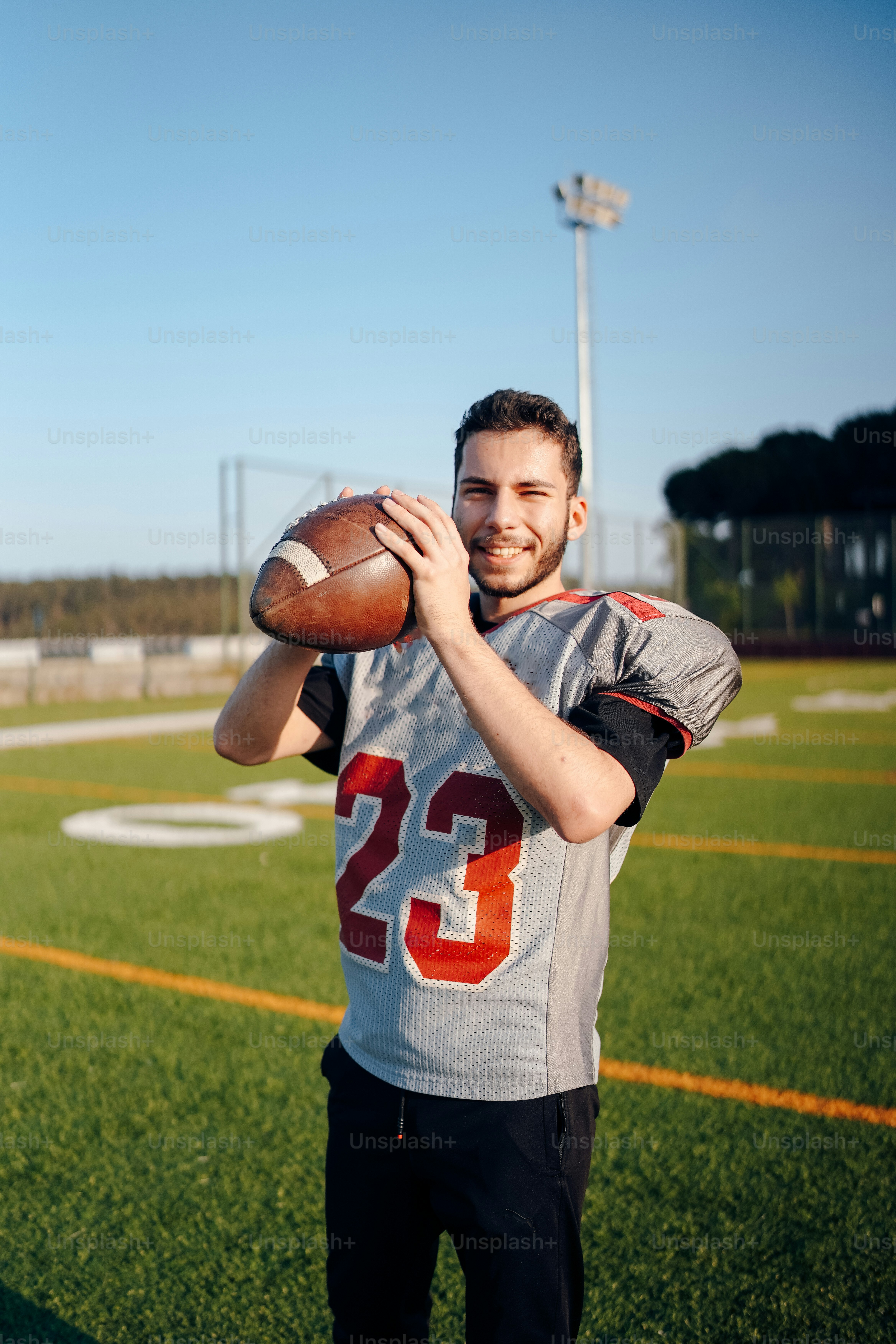 a man holding a football on top of a field