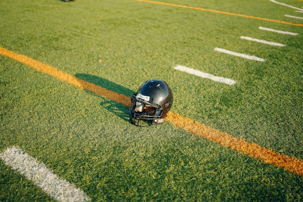 a football helmet sitting on the side of a field