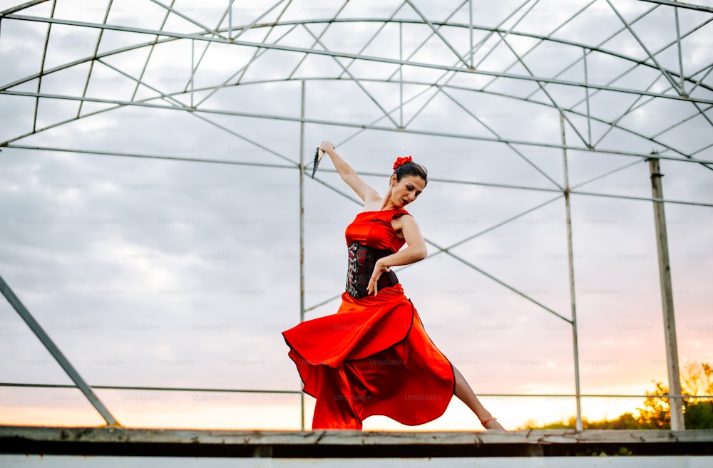 a woman in a red dress is dancing