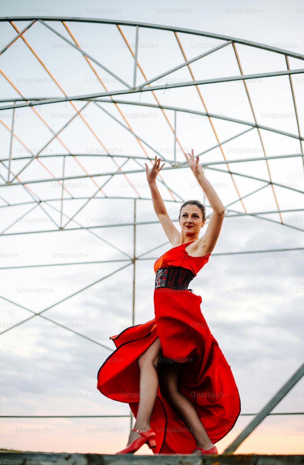 Una mujer con un vestido rojo está saltando en el aire