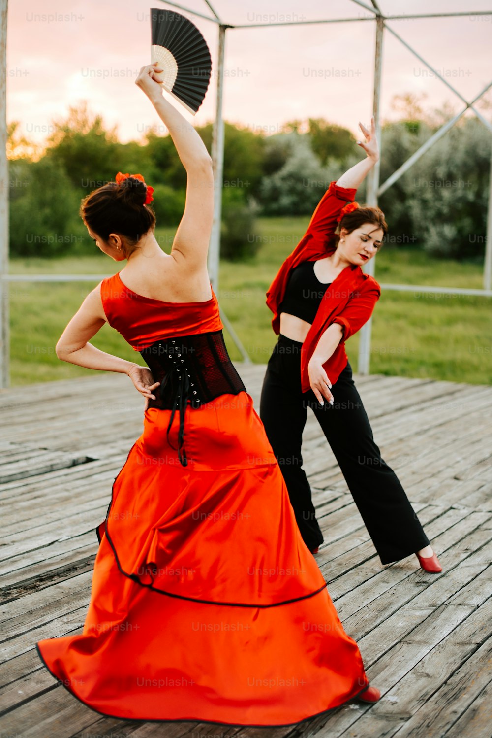 a couple of women standing on top of a wooden floor